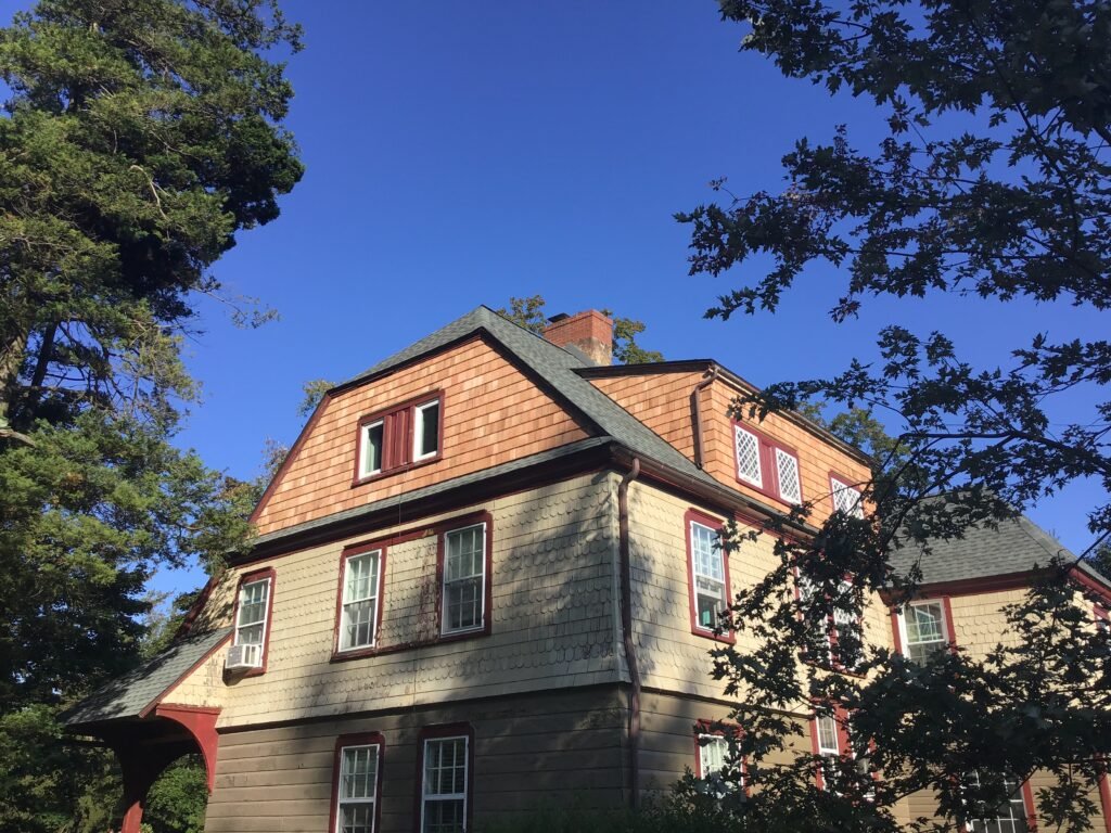 Two-story home with new cedar-shingle siding and shingle roof