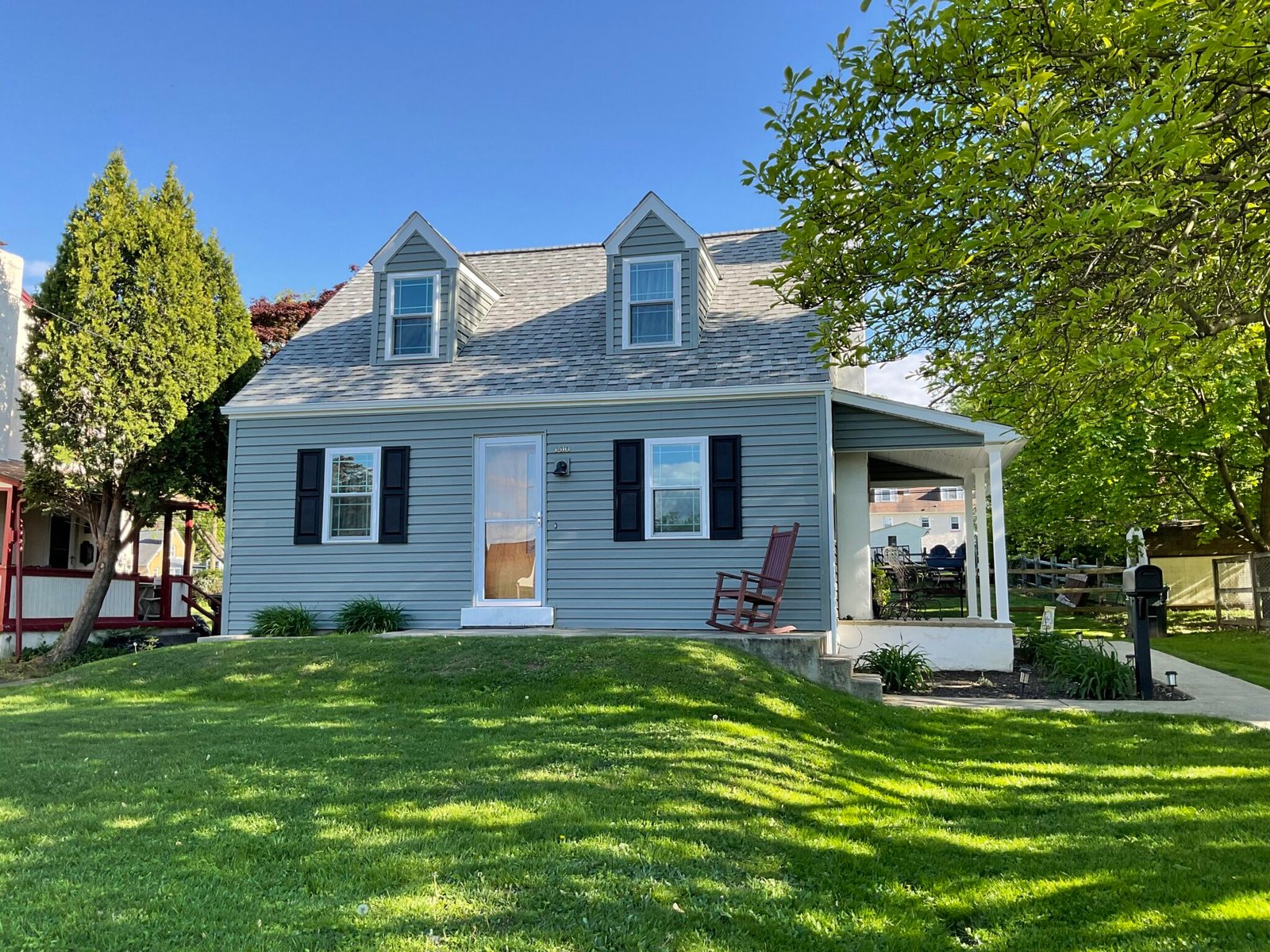 Light blue Cape Cod home with white trim, dormers and new roof