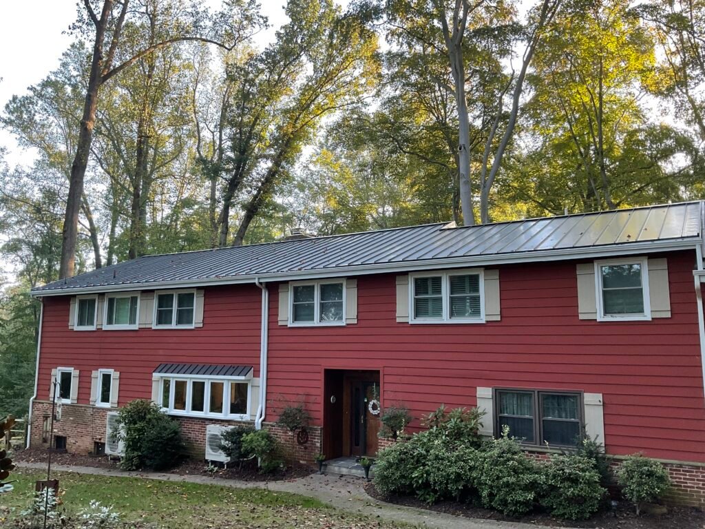 Red two-story home with standing-seam metal roof - Skyline Exteriors - Skyline Exteriors Red two-story home with gray standing-seam metal roof and white trim