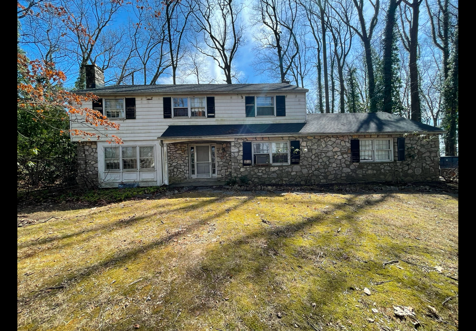 Stone colonial home with new shingle roof - Skyline Exteriors - Skyline Exteriors Stone and white two-story colonial home with new dark shingle roof