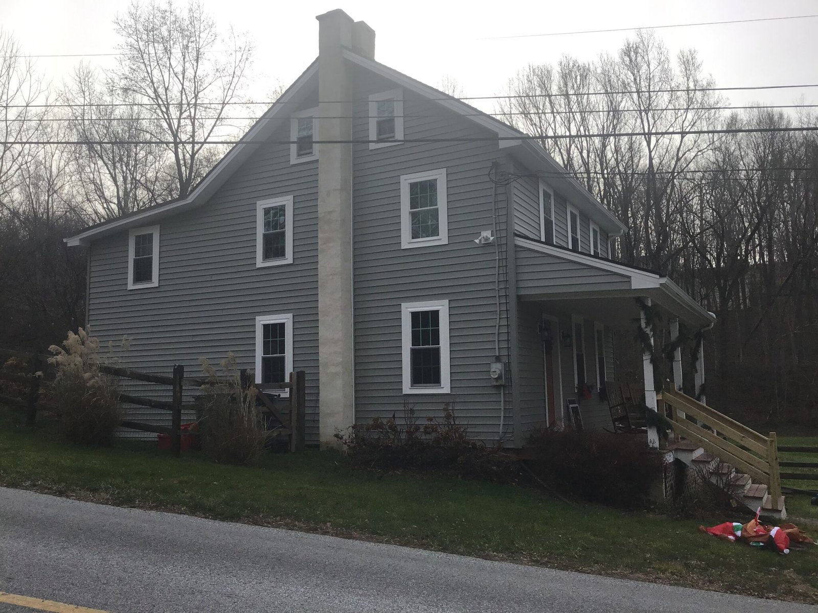Gray two-story stone farmhouse before exterior renovation