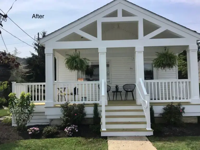 White farmhouse porch after remodel - Skyline Exteriors - Skyline Exteriors White farmhouse porch with new columns and railing after remodel