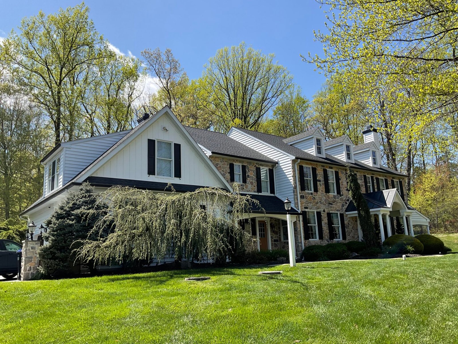 White two-story home with gray roof and brick paver front walkway