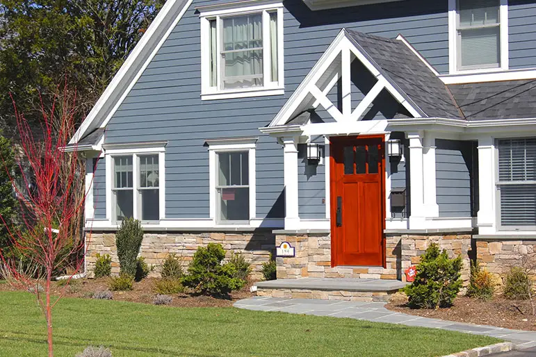 Blue vinyl siding home with red door - Skyline Exteriors - Skyline Exteriors Blue vinyl-sided home with white trim and red front door