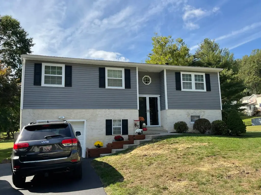 New asphalt shingle roof on a gray two-story home - Skyline Exteriors - Skyline Exteriors Two-story gray home with new asphalt shingle roof, white trim and black shutters