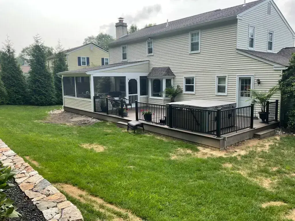 White two-story home with screened porch and black aluminum deck railing