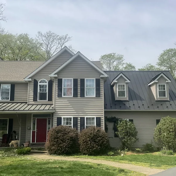 A two-story home with new siding and a metal roof completed by an exterior remodeler in Radnor Township, PA.