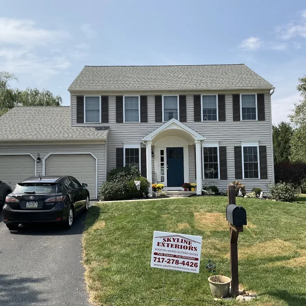 A two-story home with light siding completed by an exterior remodeler in Radnor Township, PA.