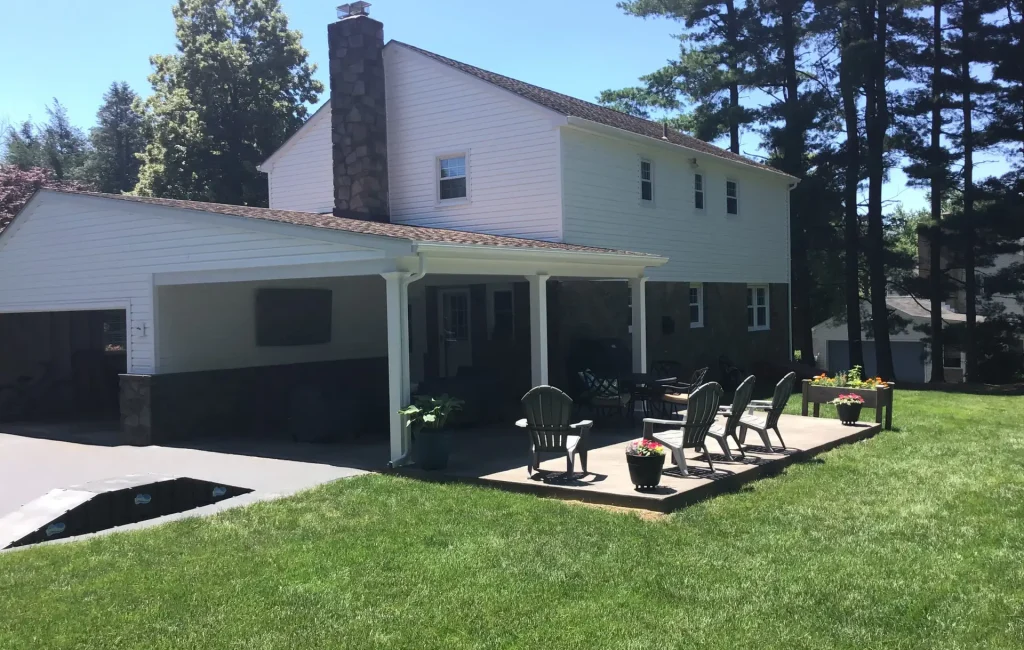 White two-story home with covered back patio and lawn