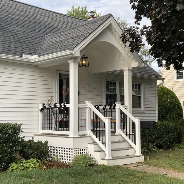 White home with new front porch, columns and black railing